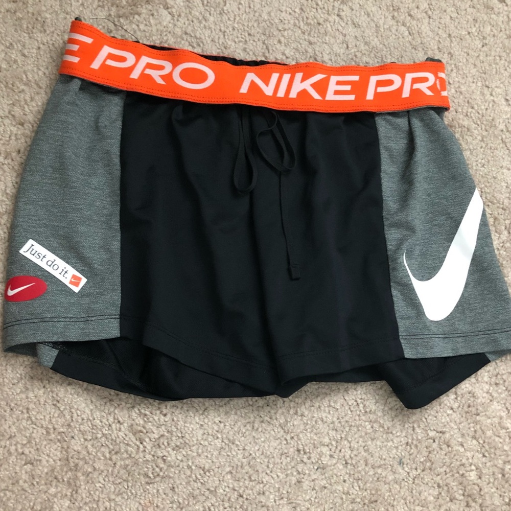 Never worn Nike gym, athletic shorts. Size small. Roll over orange waistband.